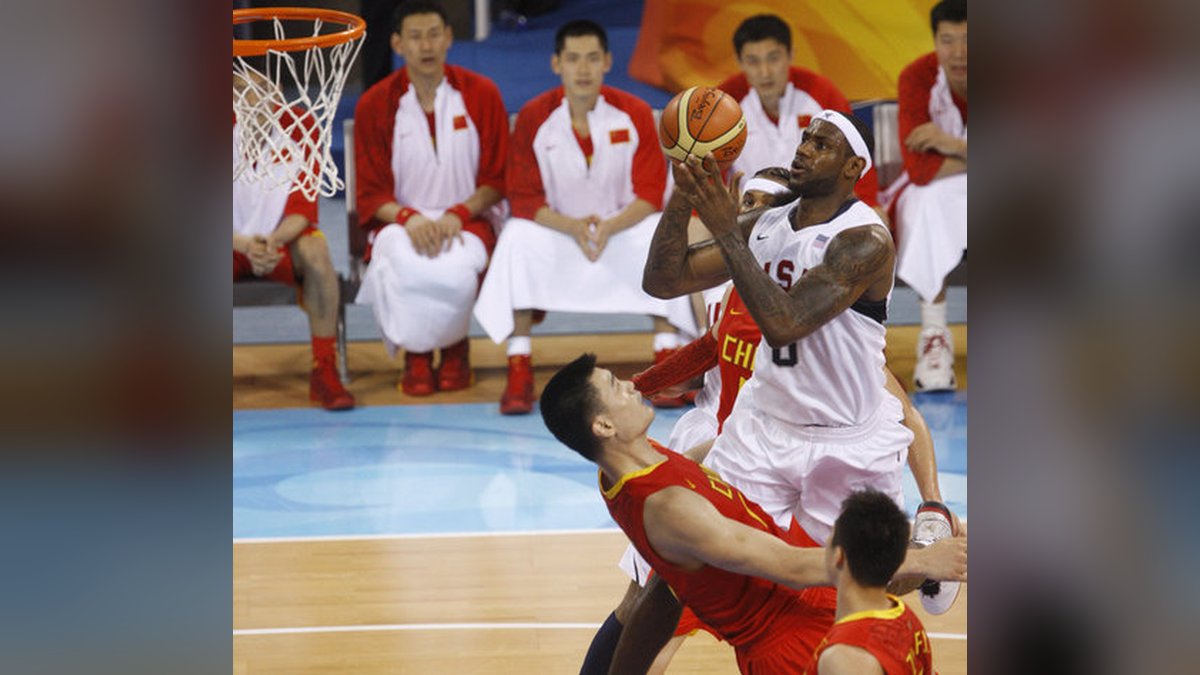 LeBron James in a white Team USA uniform rises for a shot over defenders during a 2008 Olympic basketball game