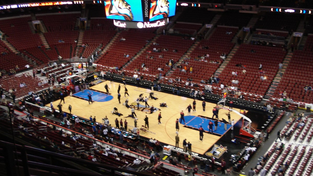 Players warm up on the court inside the Philadelphia 76ers' home arena before a game, seen from the upper deck