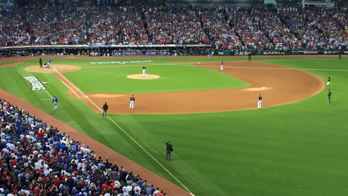 A packed crowd fills Progressive Field in Cleveland during a night playoff game on the infield below