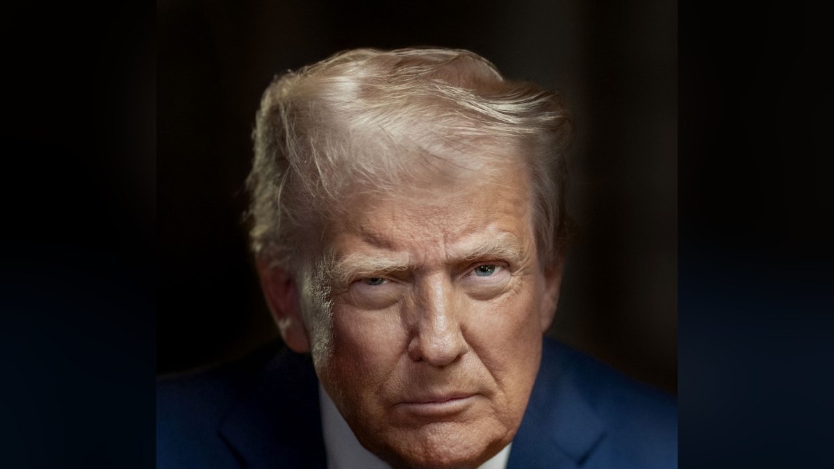 Official portrait of President Donald Trump in a navy suit standing before a dark backdrop