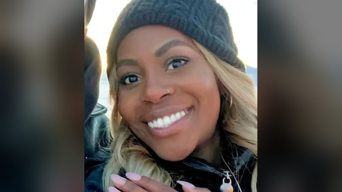 Anika Rashaun smiling in a black knit beanie