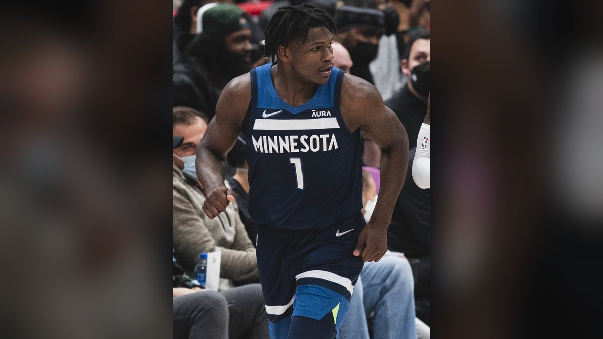 Anthony Edwards in a navy Minnesota Timberwolves No. 1 jersey jogging up the court during a 2021 game