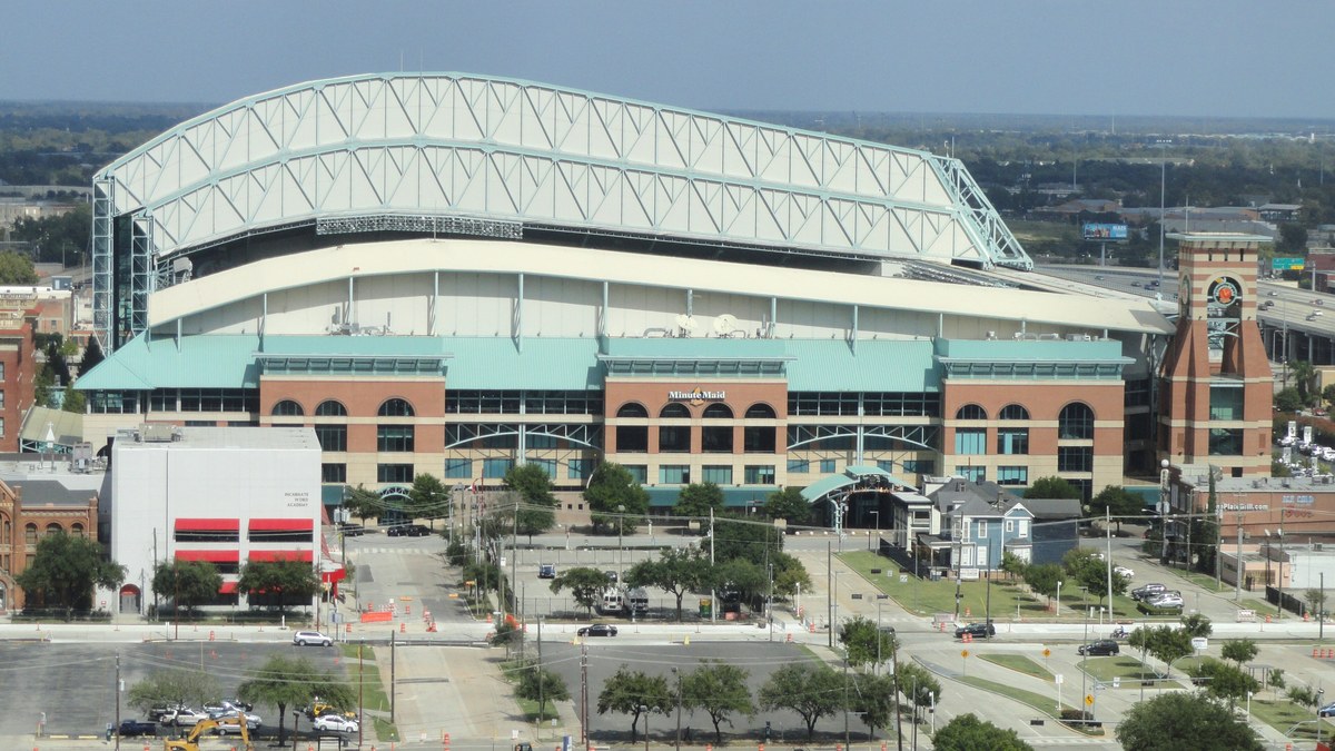 The retractable roof and brick facade of the Houston Astros' ballpark in downtown Houston on a sunny day