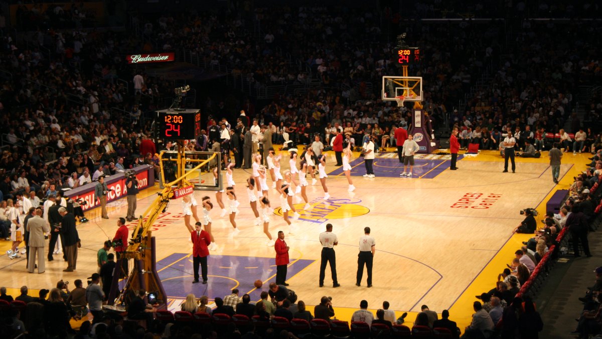 Lakers dancers perform on the purple and gold home court in Los Angeles as fans fill the arena during a break in play