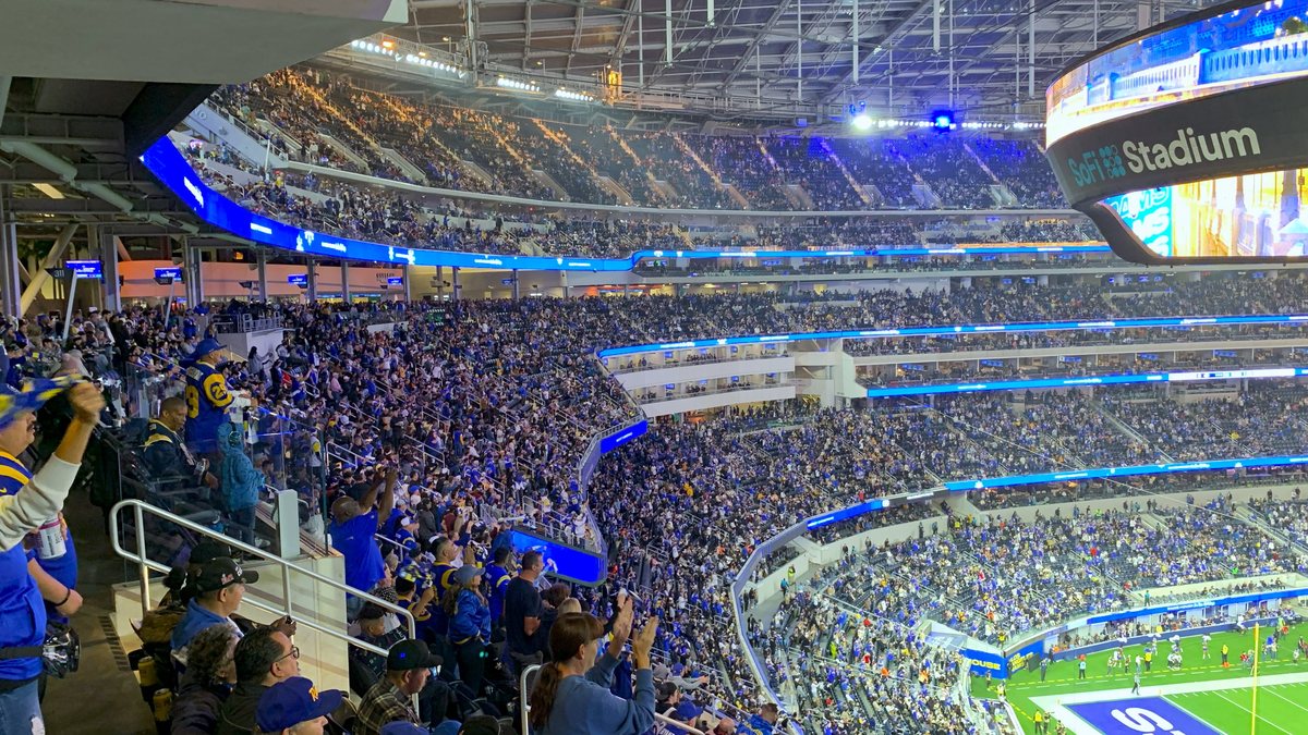 Fans fill SoFi Stadium in Inglewood during a night game under the stadium's giant video board