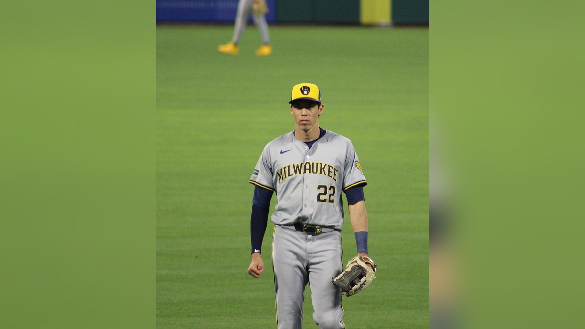 Christian Yelich standing in the outfield in a Milwaukee Brewers road uniform