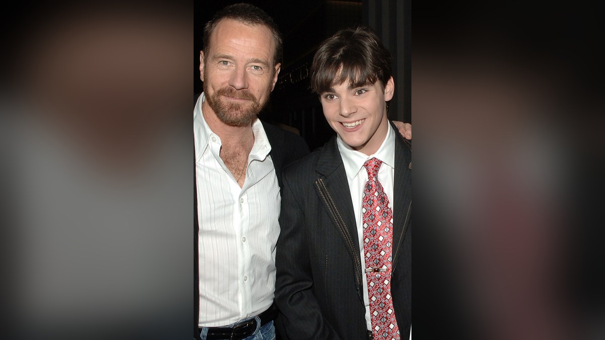 Bryan Cranston with his arm around a young RJ Mitte at an event