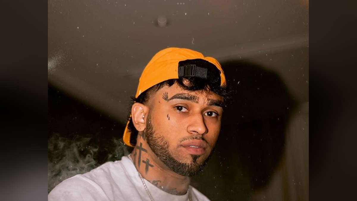 Bryant Myers in an orange cap and white T-shirt posing for a photo at night