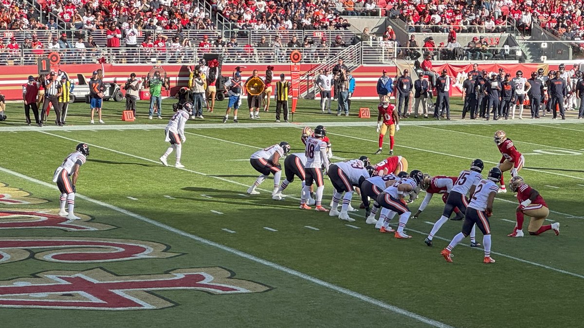 Bears quarterback Caleb Williams in a white No. 18 jersey lines up in the shotgun with the Chicago offense against the 49ers