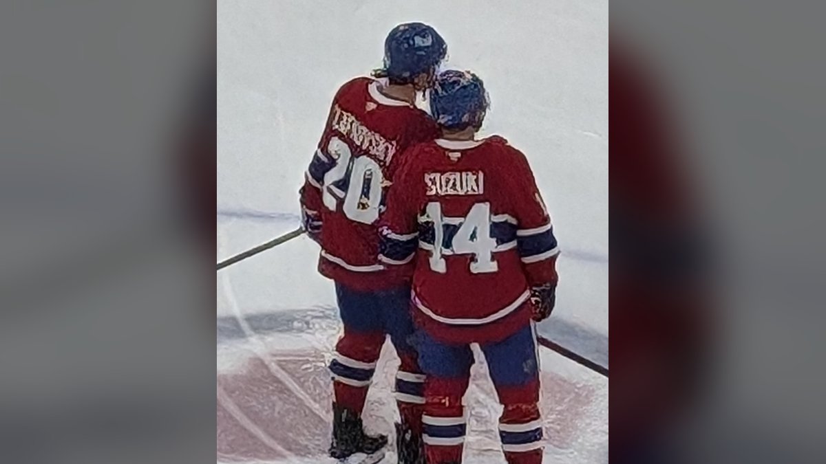 Montreal Canadiens captain Nick Suzuki seen from behind in his red No. 14 jersey beside teammate Juraj Slafkovsky (No. 20) during warmups in September 2024