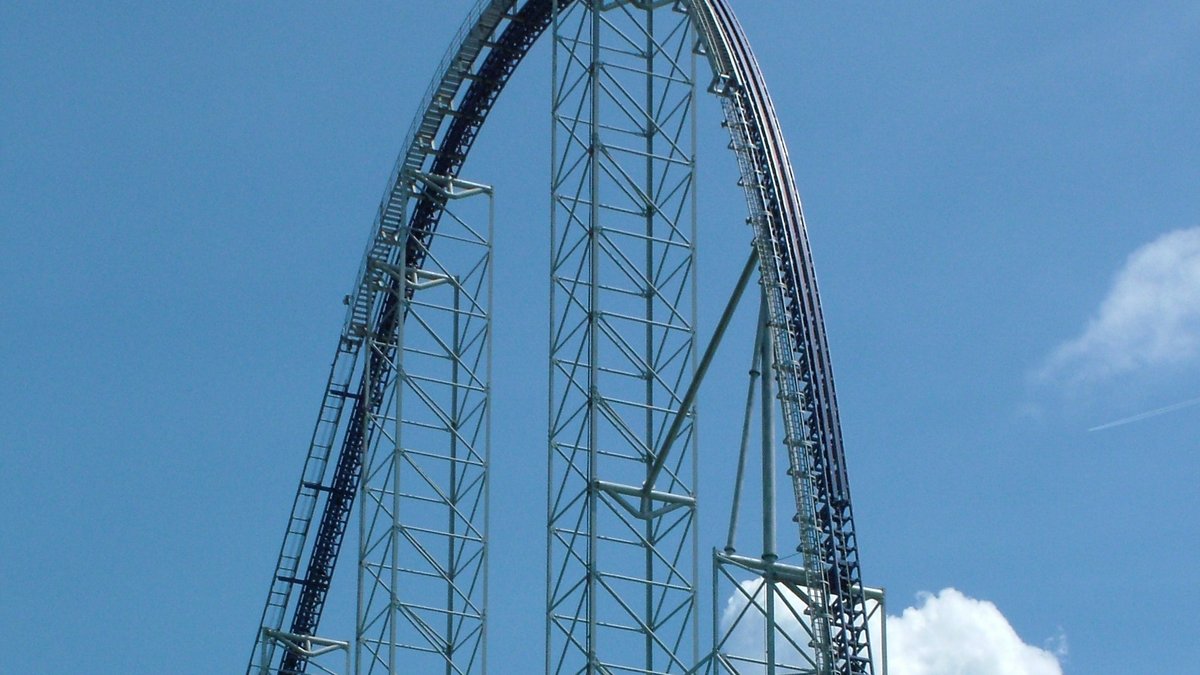 The tall blue steel lift hill of the Millennium Force roller coaster at Cedar Point under a bright blue sky