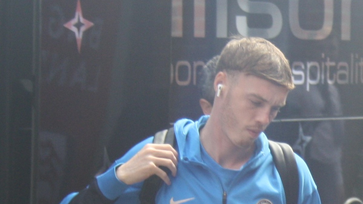 Cole Palmer in a blue Chelsea track jacket with a backpack on his shoulder arriving for a Premier League match