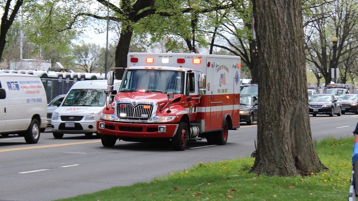 A red District of Columbia Fire and EMS ambulance driving on a city street