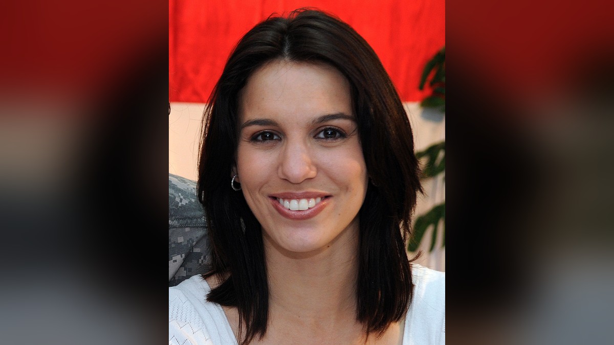 Christy Carlson Romano smiling with shoulder-length dark hair in a white top