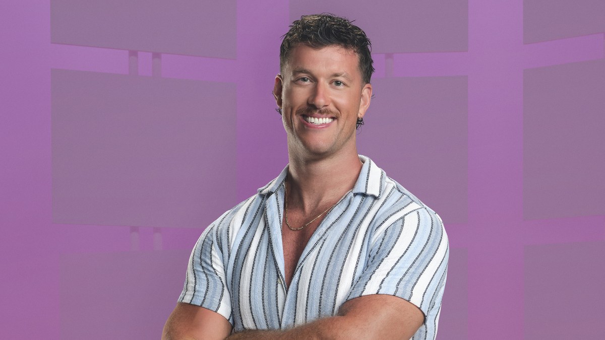 Clayton Echard smiling in a striped short-sleeve shirt against a pink backdrop