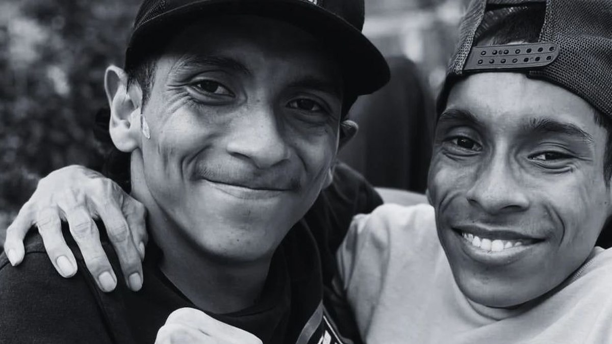 José Luis and José Armando Cevallos smiling in baseball caps in a black-and-white photo