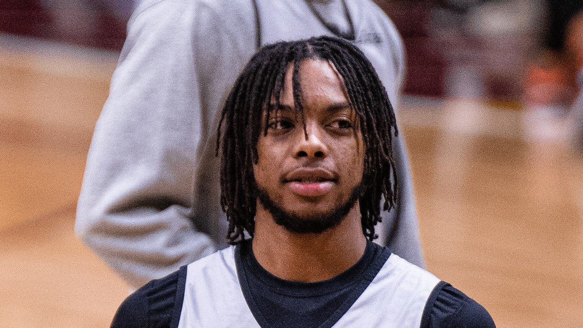 Darius Garland in a gray All-Star practice jersey holding a basketball on the court in 2022