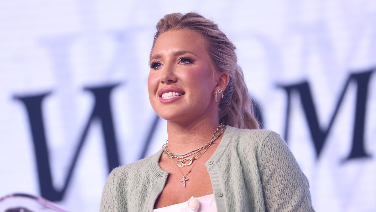 Savannah Chrisley smiling on stage in a mint green cardigan