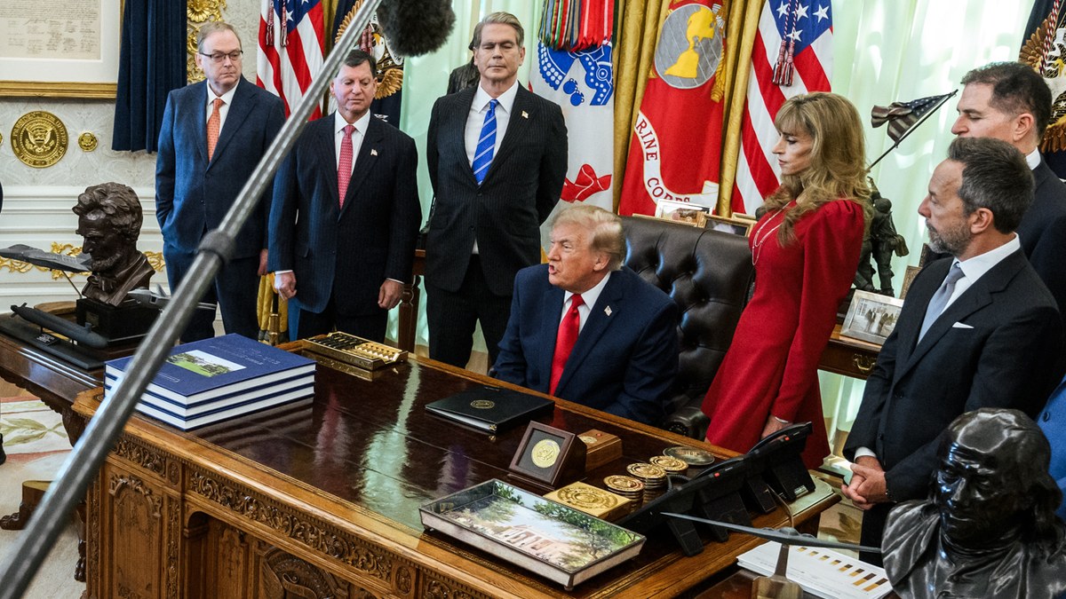 President Donald Trump speaking from the Resolute Desk as a boom microphone hangs over the Oval Office