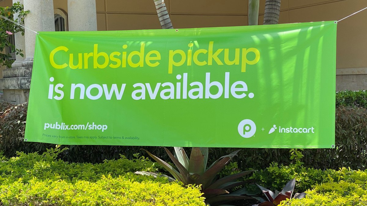 Bright green banner outside a supermarket announcing curbside pickup through the Instacart app