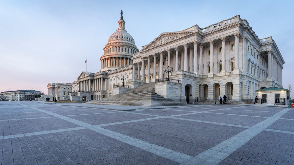 The U.S. Capitol dome and the House wing with its columns and wide stone steps above an empty plaza at sunrise