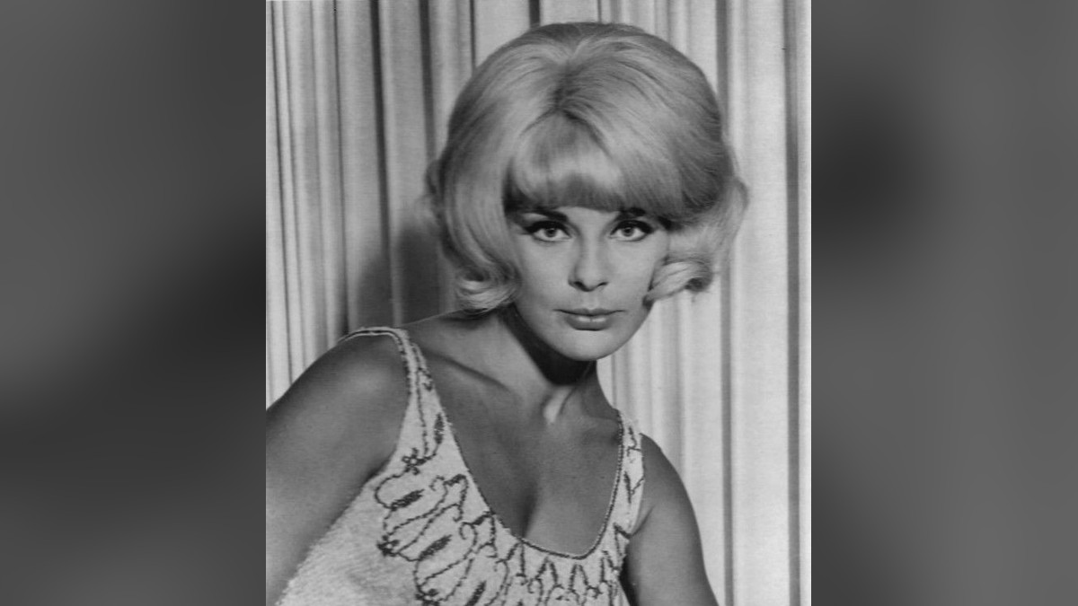 Elke Sommer in a classic black and white 1960s portrait with her blonde hair styled high