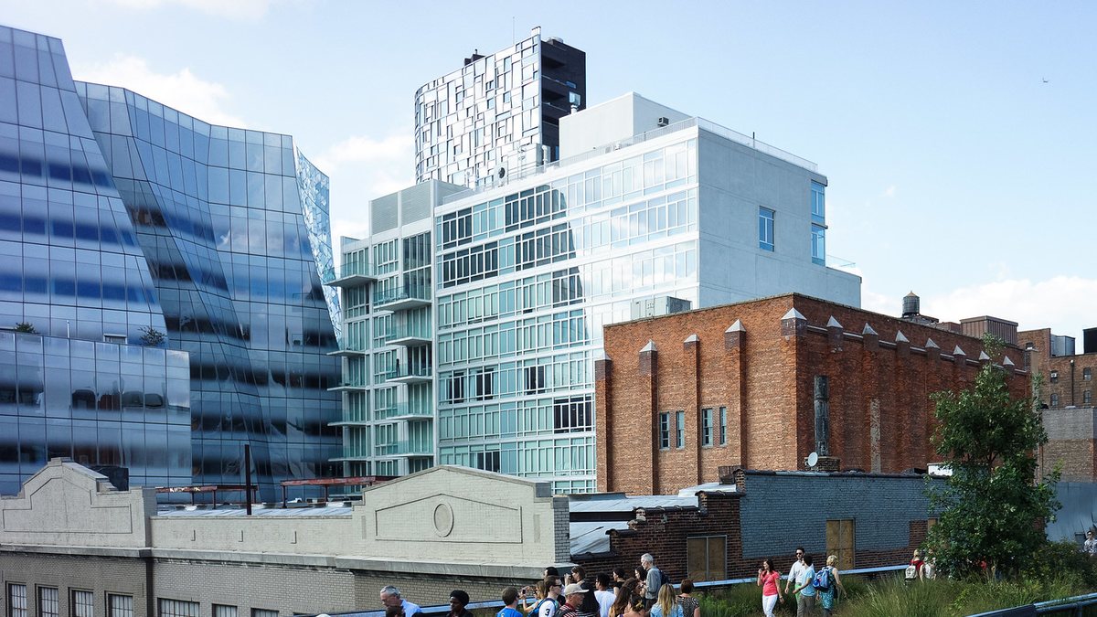 Glass towers and an old brick building rising over the High Line in the Chelsea neighborhood of Manhattan