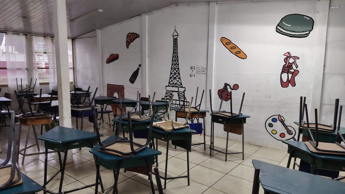 An empty classroom with desks and painted wall murals