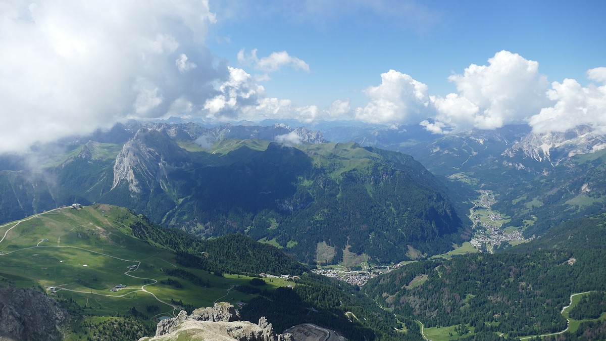 Green mountain slopes and rocky peaks above the Val di Fassa in the Italian Dolomites