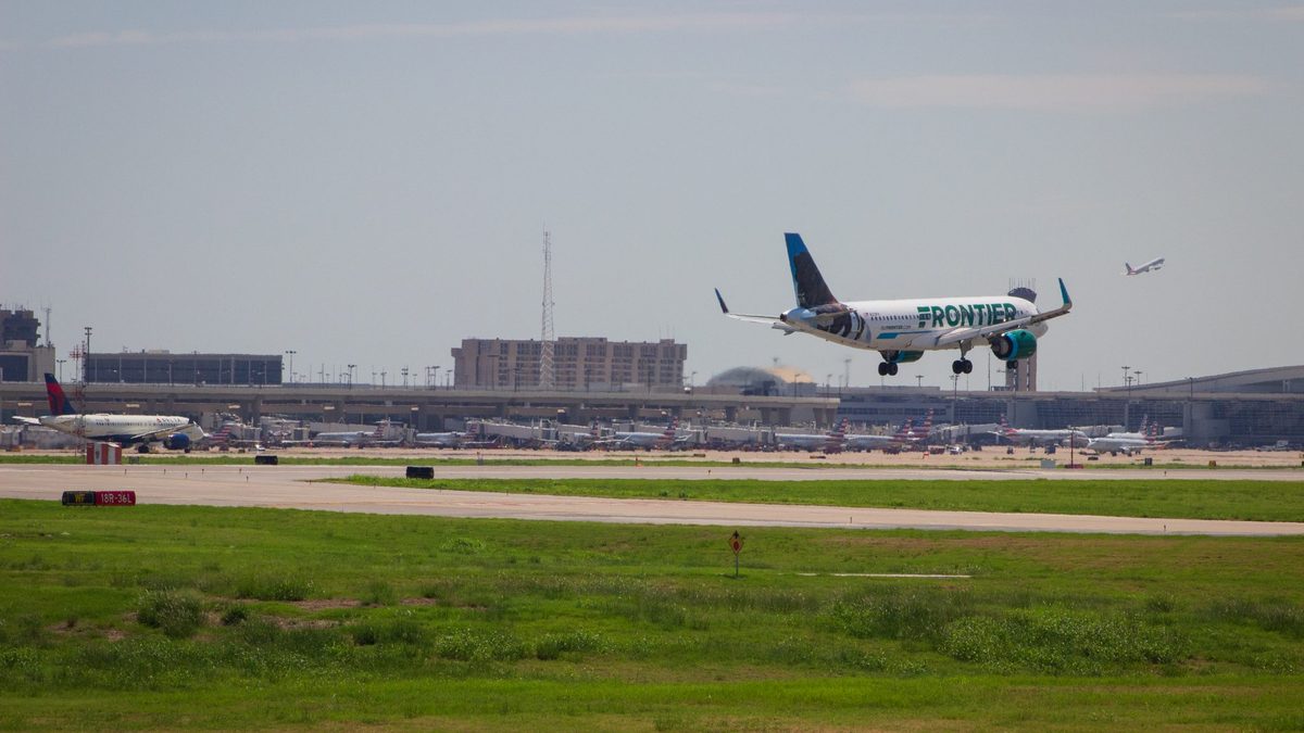 A Frontier Airlines jet landing as a Delta jet takes off