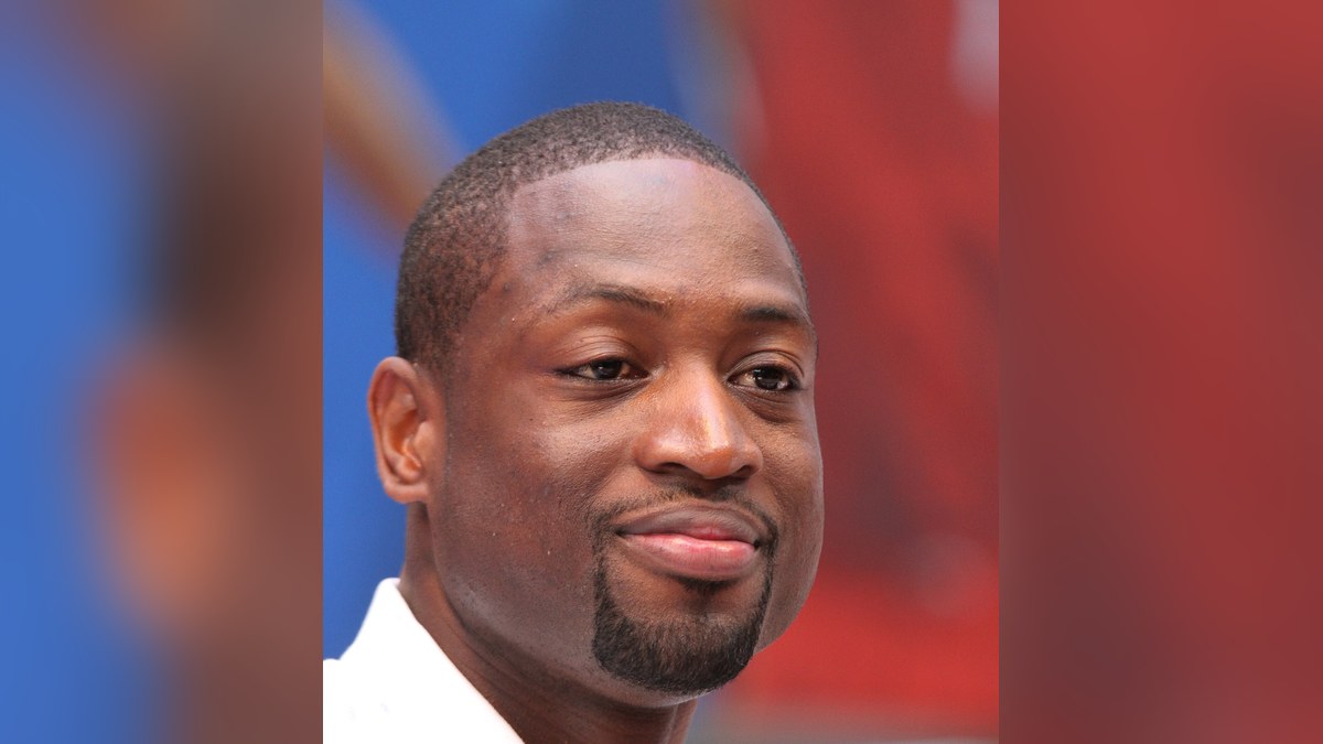 Dwyane Wade smiling in a white shirt