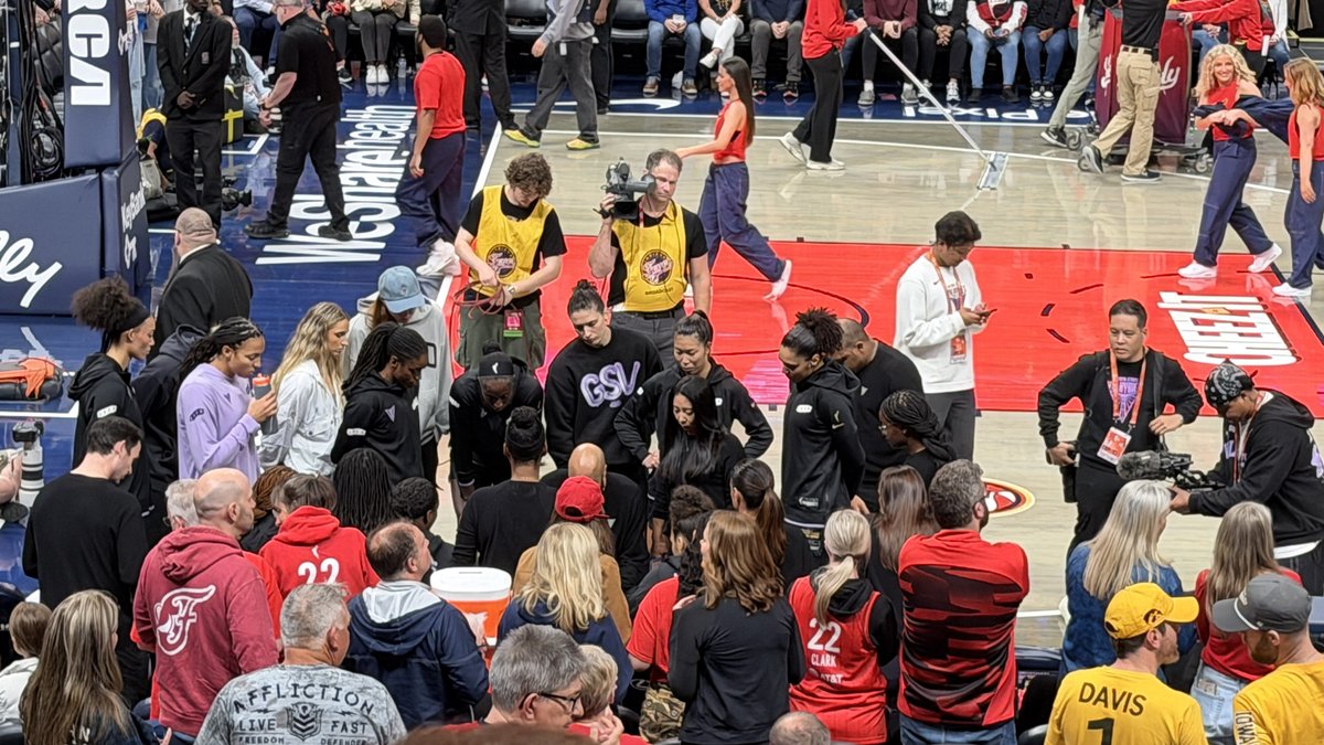 Fans in Indiana Fever jerseys, including Caitlin Clark No. 22 shirts, crowd courtside at the Fever home arena during a May 2026 game