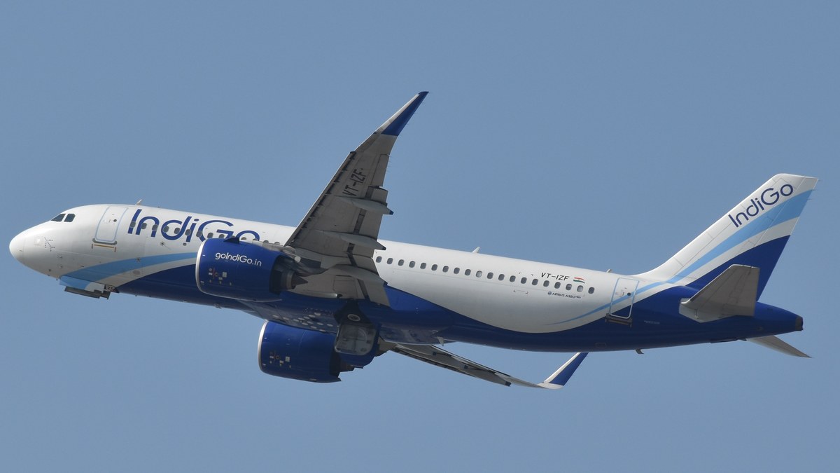 An IndiGo Airbus A320neo climbing against a clear blue sky