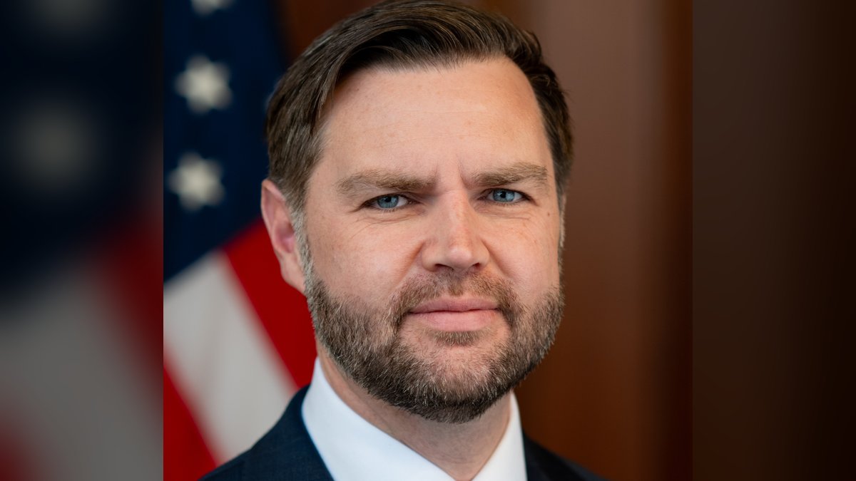 Vice President JD Vance in a dark suit in front of an American flag