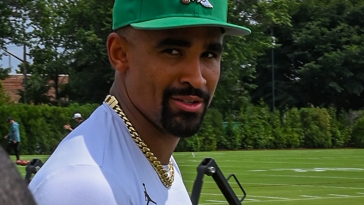 Jalen Hurts in a green Eagles cap and gold chain at training camp