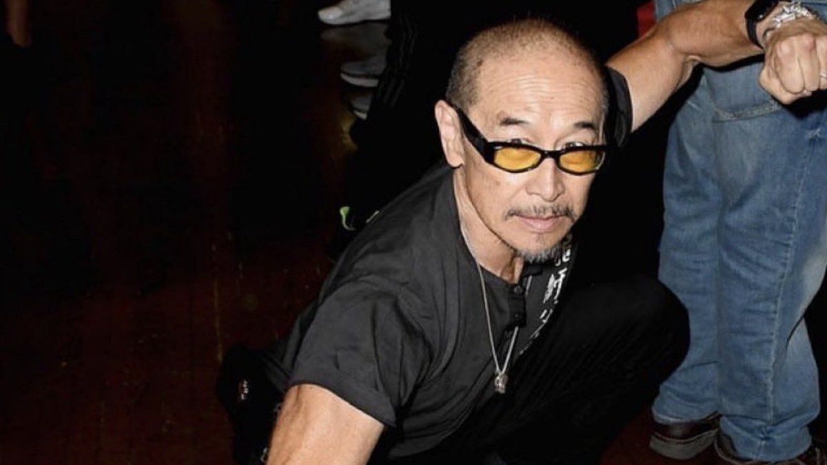 James Lew in yellow sunglasses crouching in a martial arts stance