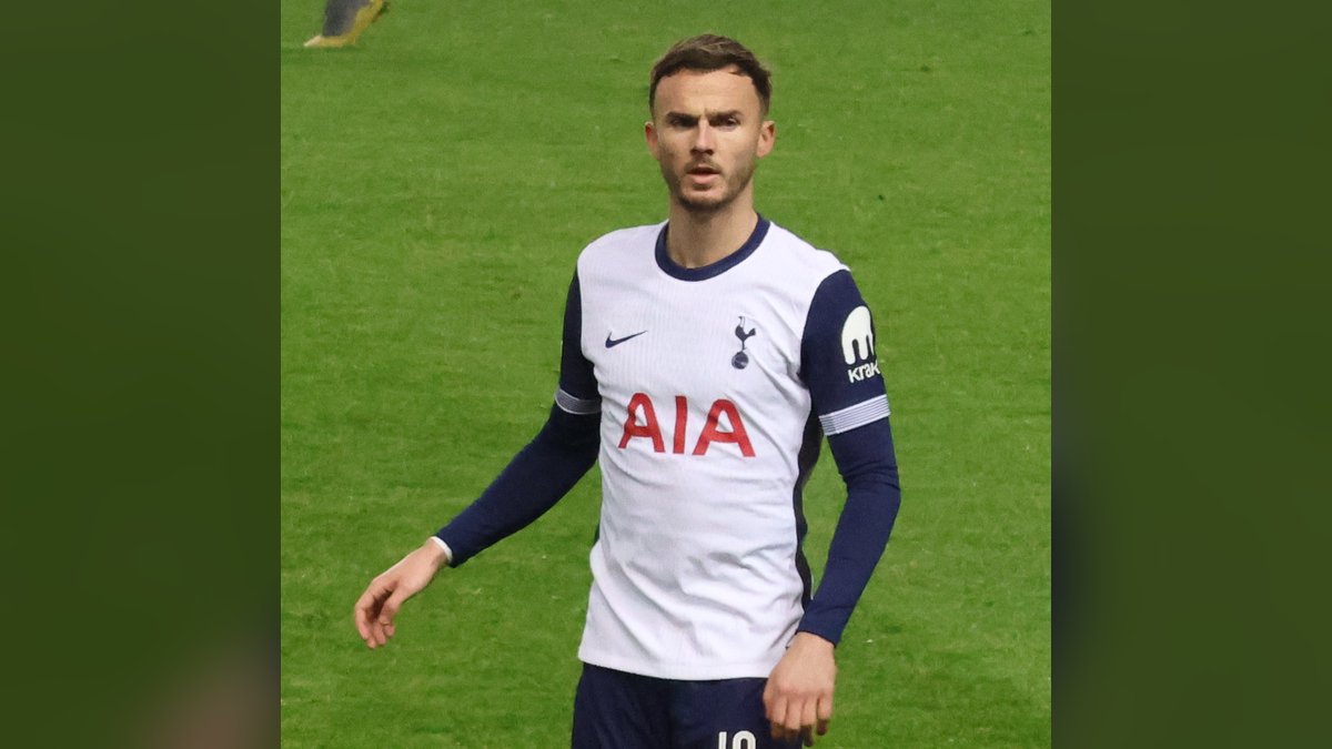 James Maddison in a white Tottenham kit stands on the pitch during a match against Rangers in December 2024
