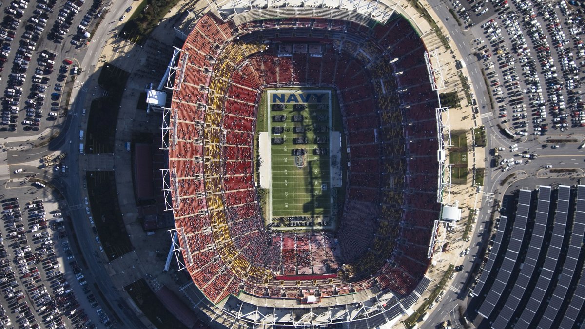 Aerial view of FedEx Field in Landover Maryland with red seats packed around a green football field