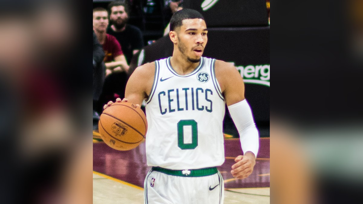 Jayson Tatum dribbles in a white Celtics uniform