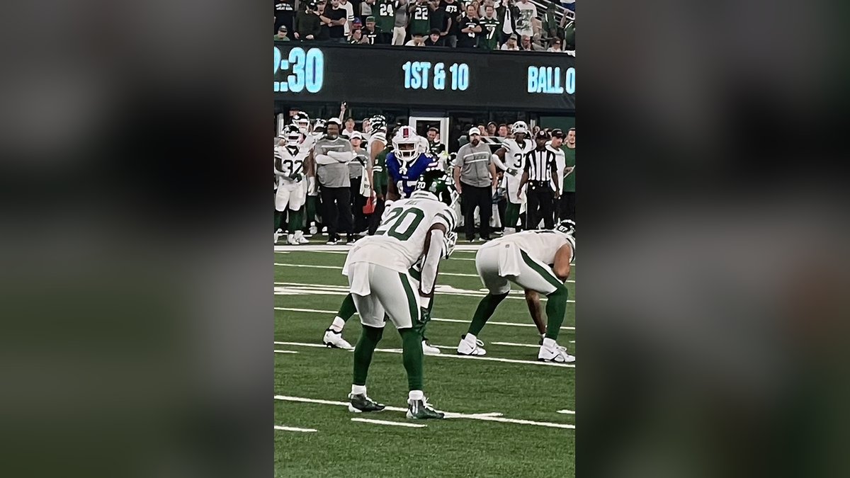 Jets running back Breece Hall in a green and white uniform looks ahead on the field