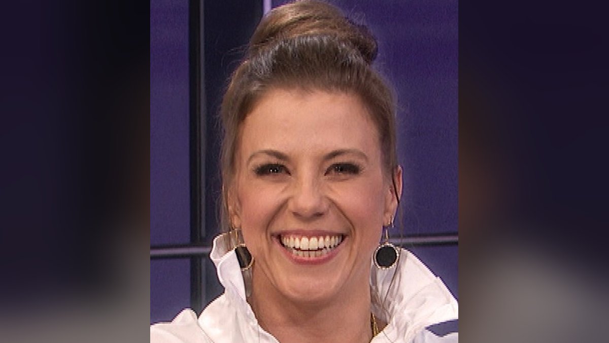 Jodie Sweetin smiling with her hair pulled up in a white blouse