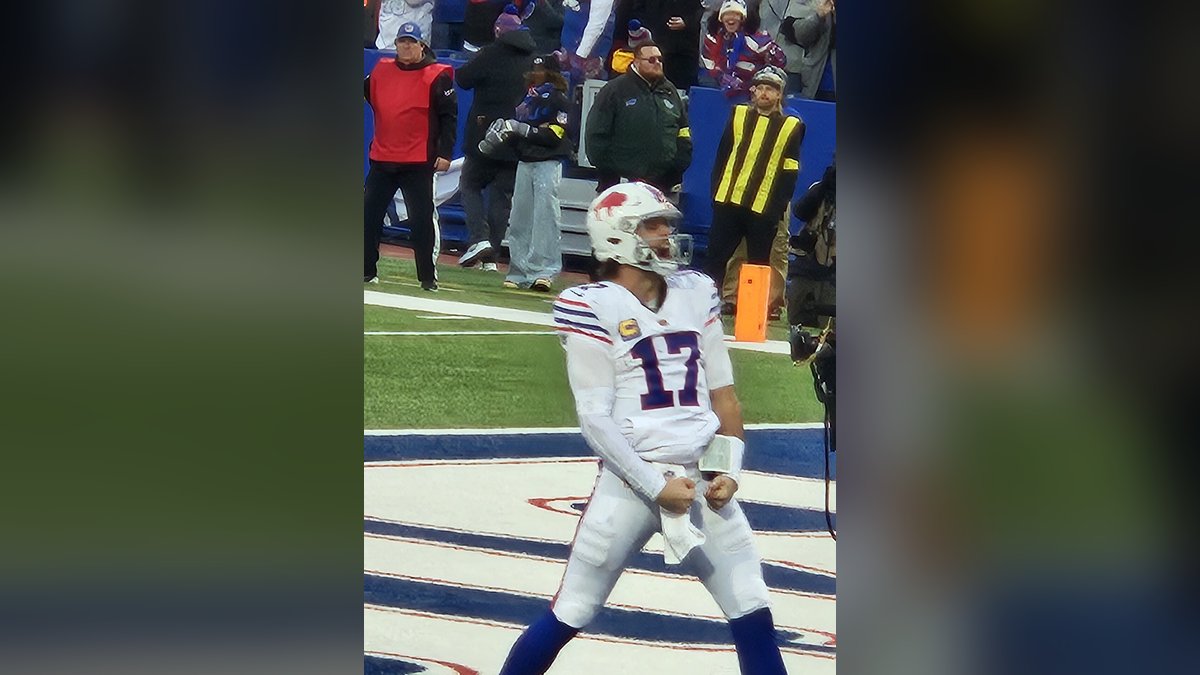 Buffalo Bills quarterback Josh Allen in a white number 17 jersey celebrates a touchdown on the field in front of fans in 2025