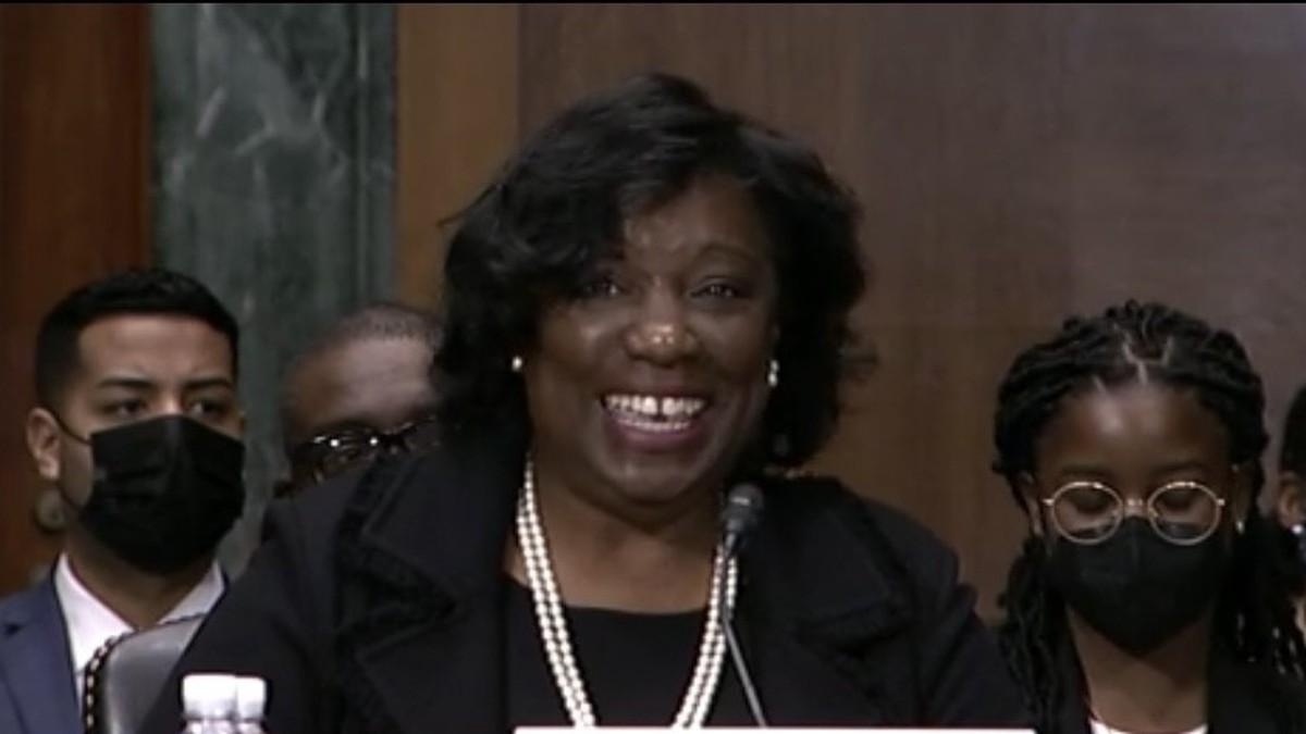 Judge Trina Thompson smiling at a Senate confirmation hearing behind a name placard