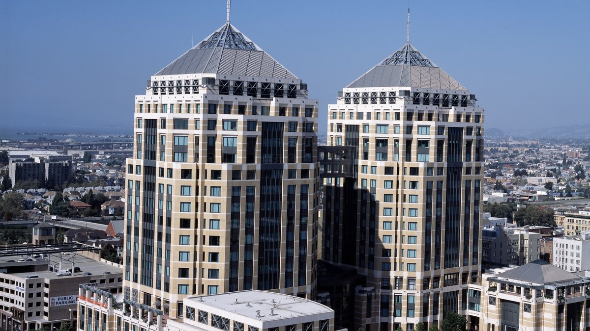 The twin towers of the Ronald V. Dellums Federal Building in downtown Oakland, home to the federal courthouse, with pyramid roofs under a clear blue sky