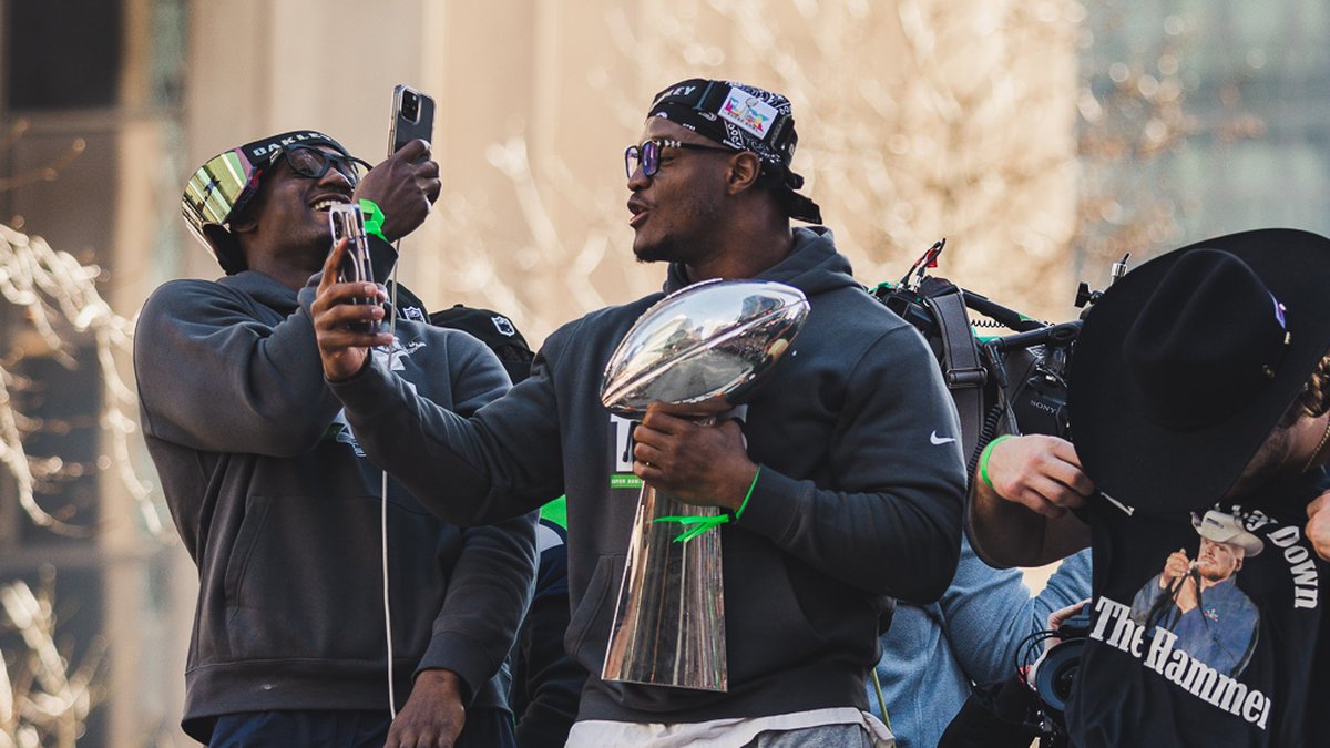 Kenneth Walker III holds the Vince Lombardi Trophy during the Super Bowl LX victory parade in Seattle
