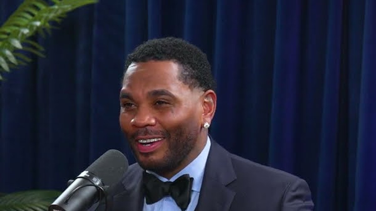 Kevin Gates smiling in a tuxedo and bow tie during a podcast interview