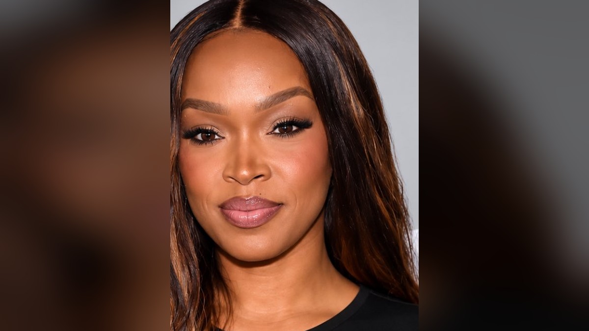 Khadijah Haqq with long highlighted brown hair against a light gray backdrop