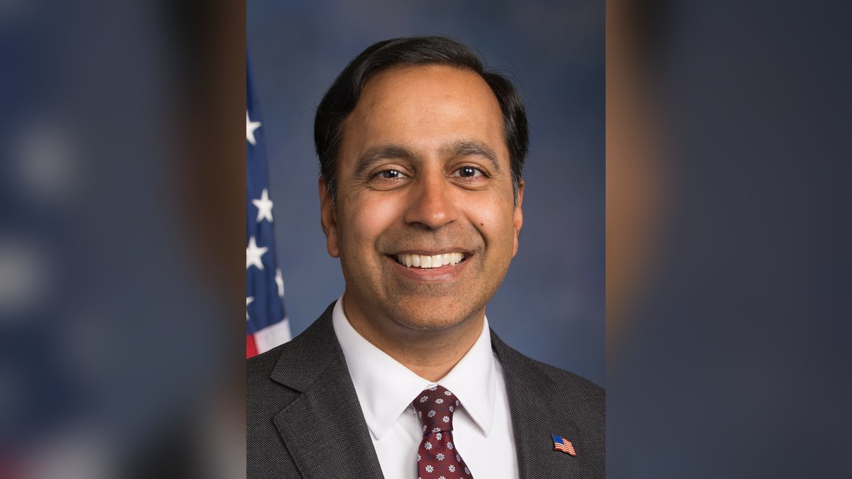 Official congressional portrait of Rep. Raja Krishnamoorthi smiling in a dark suit and red tie