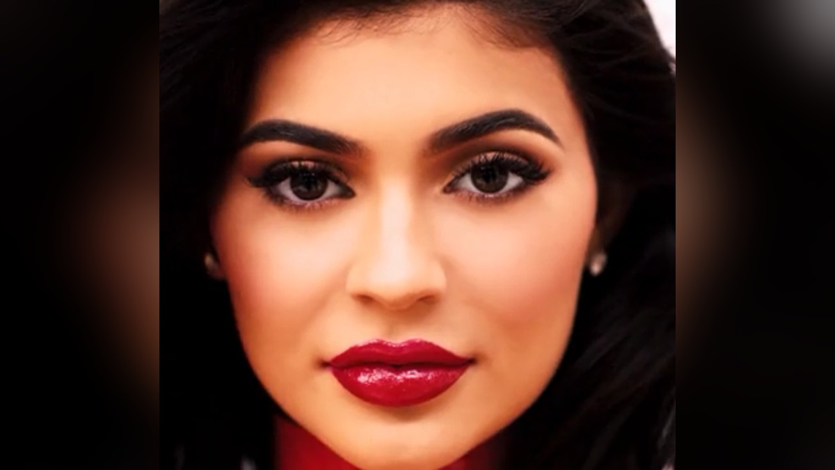 Kylie Jenner with long dark hair and red lipstick looking straight at the camera