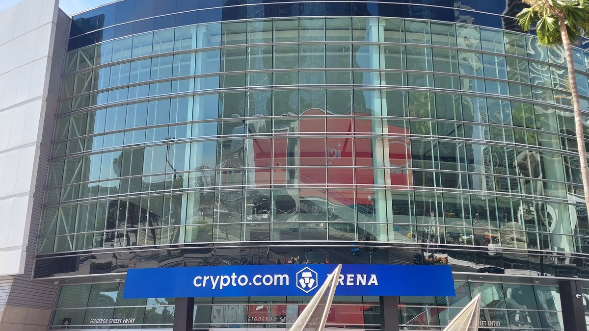 The glass front of Crypto.com Arena, home of the Los Angeles Lakers, under a clear blue sky in downtown Los Angeles